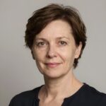 Портрет уверенного российского бизнесмена с дружелюбным взглядом на размытом нейтральном фоне в студии